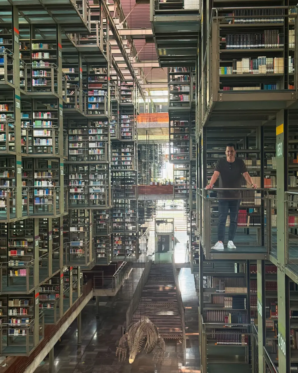 Alex on a walkway inside the Biblioteca Vasconcelos in Mexico City, stacks running away in every direction