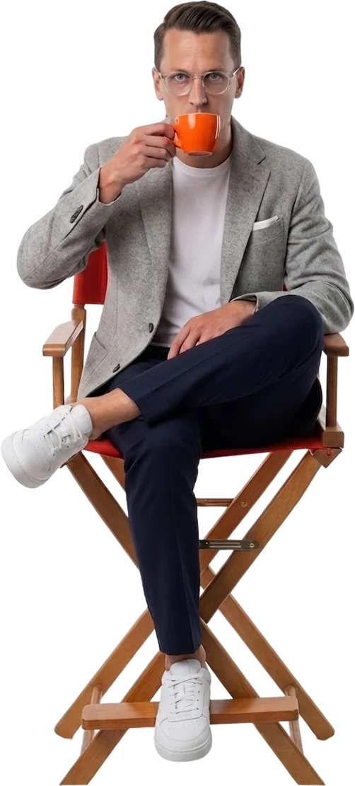 Alex McCarthy, sitting in a director&rsquo;s chair with a cup of coffee
